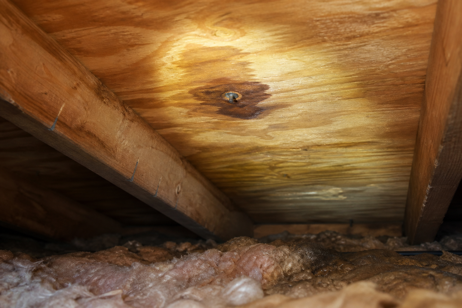 Localized water staining on roof decking viewed from an attic